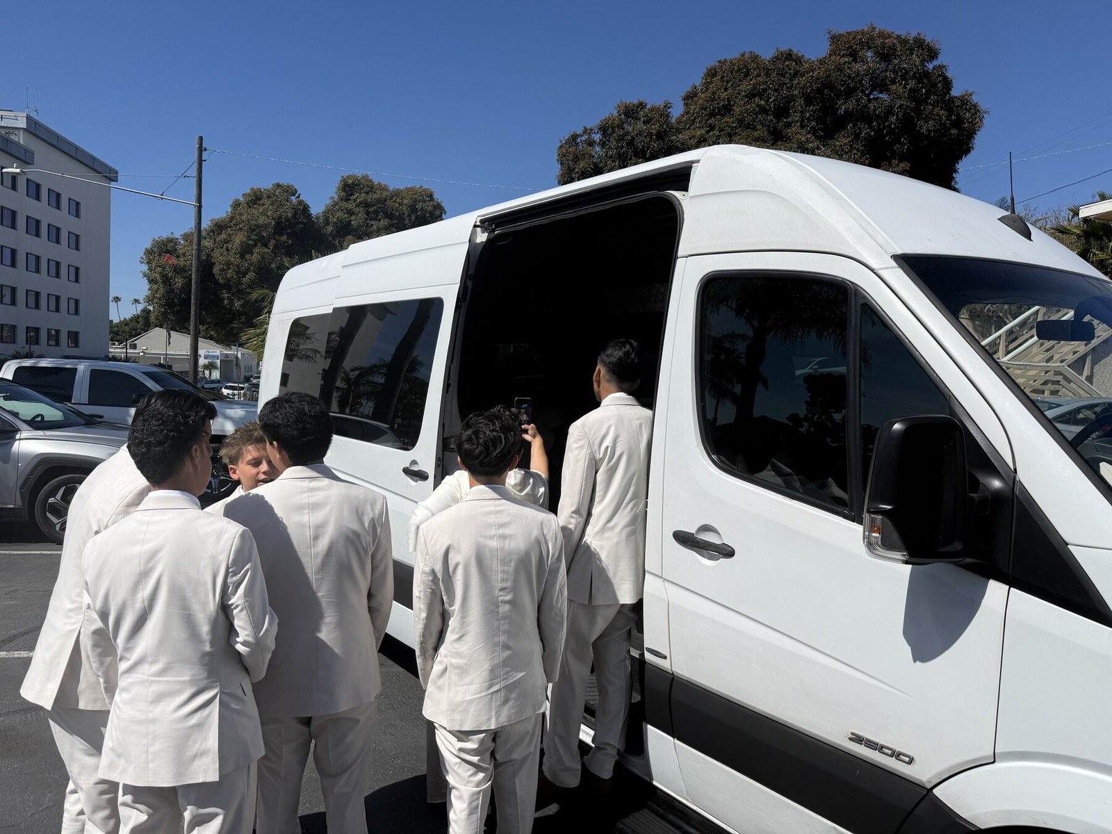 Group boarding a Blue Skies Chauffeured Transportation Sprinter van for a night out