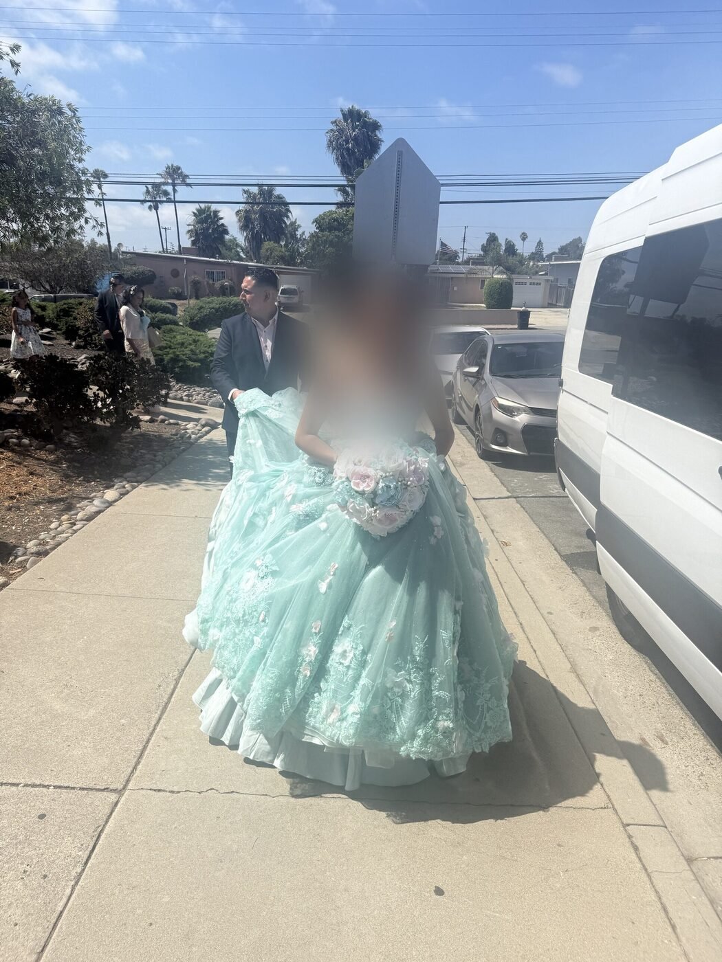 A quinceañera arriving at a Blue Skies Chauffeured Transportation Sprinter van in her celebration gown