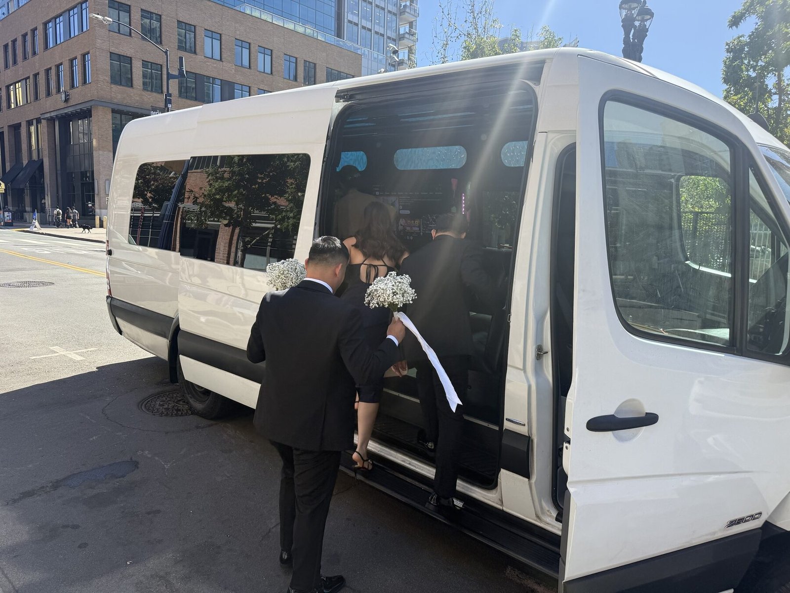 A wedding party boarding a Blue Skies Chauffeured Transportation Sprinter van